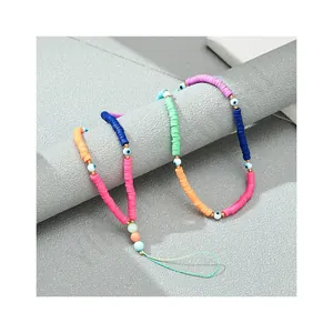 Colorful polymer clay lanyard with evil eye beads and golden accents on stone block
