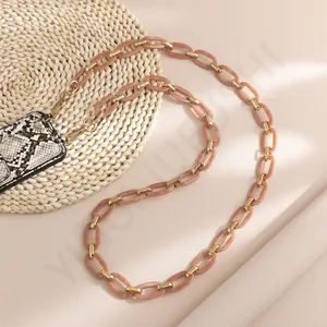 Detail of pink acrylic phone chain with gold rings and snakeskin pattern card holder