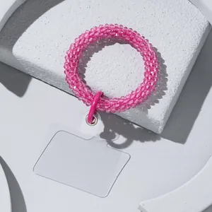 Pink beaded phone wrist strap on marble decor with clear connector patch for phone case