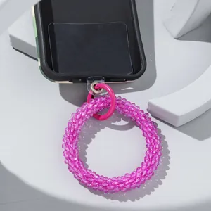 Detail of bright pink faceted glass bead phone strap with metal ring and clear patch