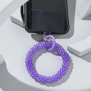 Close-up of purple beaded phone wrist strap with metal clasp and clear patch connector