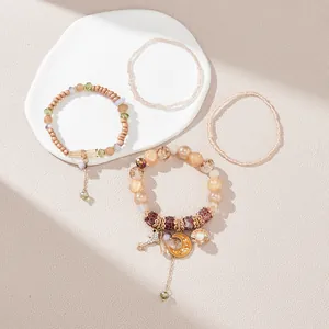 Detail of four-piece bohemian beaded bracelets with moon, shell, and star charms