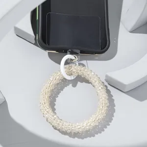 Detailed view of champagne beaded phone wristlet with white clasp and clear connector