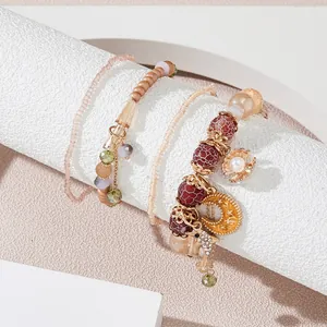 Detail of bohemian layered beaded bracelets with shell and seahorse charms on white stand
