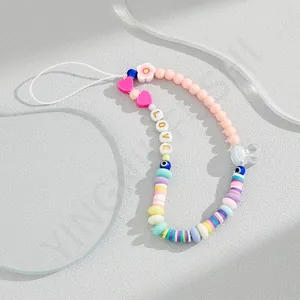 Close-up of colorful macaron acrylic beads and LOVE letter charms on a phone lanyard