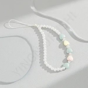Detail of macaron heart beads and white imitation pearls on a sweet beaded phone charm