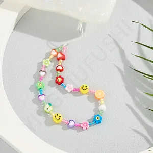Detail of colorful macaron acrylic beads with smiley face and floral phone lanyard charm