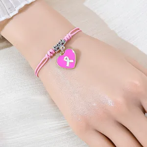 Rosa geflochtenes Armband mit Emaille-Herzanhänger und Brustkrebs-Schleifensymbol