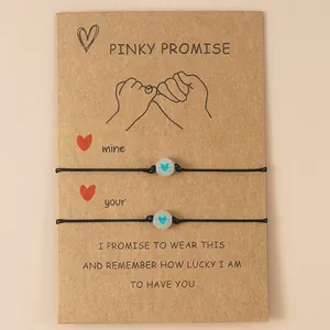 Detail van Pinky Promise kaart met twee verstelbare armbanden en lichtgevende hartvormige kralen