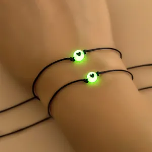 Lichtgevende hartkraal op zwarte gevlochten armbanden met een heldergroene gloed in donker