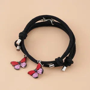 Nahaufnahme der Herz-Magnetverschlüsse und Schmetterlings-Anhänger an schwarzen Armbändern