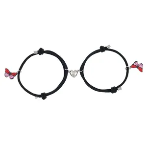 Details von verstellbaren schwarzen Webarmbändern mit Magnetherz und Schmetterlingsanhängern