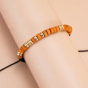 Morse code bracelet with orange wooden beads and gold metallic accents on an adjustable cord