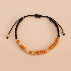 Detail of handmade Morse code bracelet with wooden beads and adjustable black woven cord