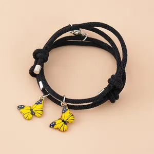 Detailansicht der gewebten Partnerarmbänder mit gelben Schmetterlingen und Magnetverschluss