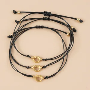 Set di tre braccialetti in corda cerata nera regolabile con nodi a cuore dorati
