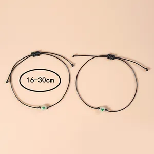 Detail van verstelbare zwarte geweven armbanden met lichtgevende groene hartkralen