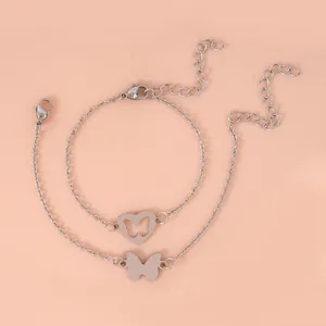 Zilveren roestvrijstalen vlinder hart armbanden set op een roze achtergrond