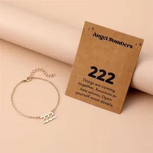 Detailed shot of golden 222 angel number bracelet on kraft paper meaning card