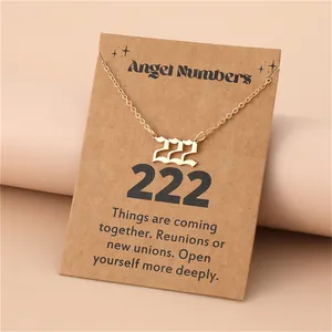 Golden necklace detail with 222 Angel Number pendant on a minimalist kraft paper display card