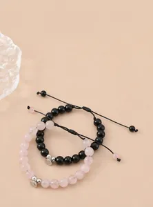 Macro detail of magnetic heart charm on pink and black crystal bead bracelets