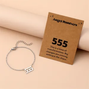 Detail of silver angel number 555 bracelet with symbolic card on soft pink background