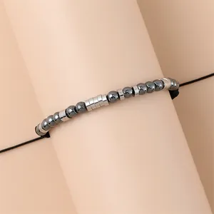Morsecode armband met hematiet kralen en verstelbaar zwart koord op een display