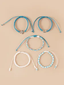 Détail de cinq bracelets océaniques avec perles bleues et un pendentif tortue en argent