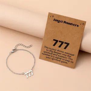 Detail view of silver 777 angel number bracelet with card on pink background