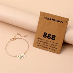 Macro shot of gold angel number 888 bracelet with meaningful gift card on soft background