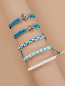 Détail du lot de cinq bracelets de cheville tissés avec breloques tortue et vague