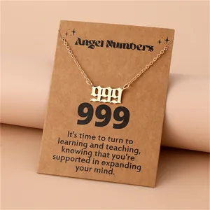 Close-up of gold 999 angel number necklace displayed on spiritual meaning card