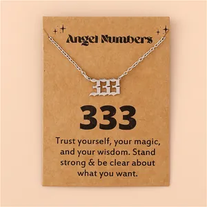 Vue macro du pendentif chiffre des anges 333 en acier argenté sur carte de message