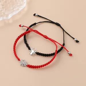 Detail van de rood-zwarte gevlochten spin en web armbanden met verstelbare trekkoordsluiting