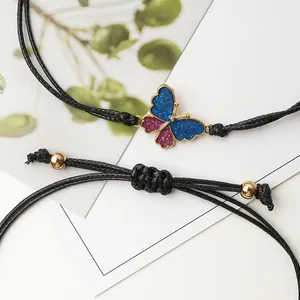 Bracciale regolabile in cordino nero con farfalla glitterata blu e perline dorate