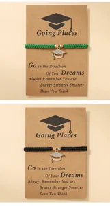 Detailed view of woven graduation bracelets with rhinestone mortarboard charms on cards