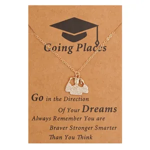 Macro detail of golden graduation pendant with white crystals on a kraft paper card
