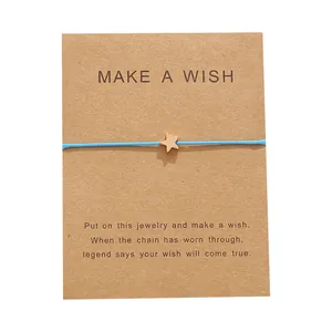 Bracciale Make a Wish fatto a mano con cordino blu e stella dorata su carta kraft
