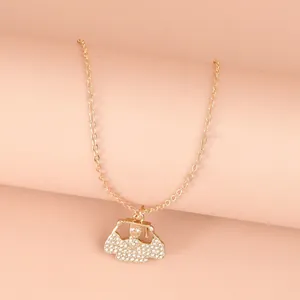 Macro shot of gold graduation charm necklace with rhinestones and fine link chain