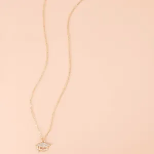 Detailed close-up of golden graduation cap pendant with sparkling crystals and fine tassel