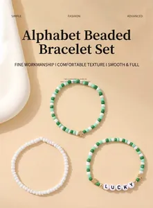 Détail de trois bracelets bohèmes en perles avec trèfle porte-bonheur et perles de lettres