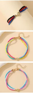 Detail of colorful multilayer beaded bracelets with heart pendants and lobster clasps