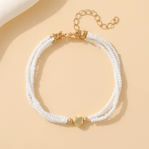 Minimalist double-layer white seed bead bracelet with golden heart pendant and lobster clasp