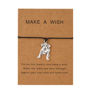 Bracelet en corde noire tissée avec pendentif chien argenté sur carte de vœux