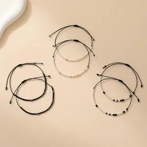 Trois bracelets Morse en perles sur cordon ciré noir avec nœuds coulissants réglables