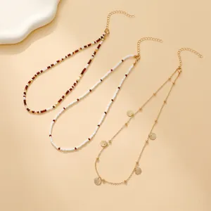 Bohemian layered beaded necklaces with gold shell pendant on a warm beige background