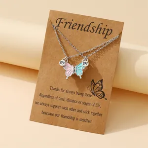 Collane magnetiche a farfalla BFF con pendenti in smalto rosa e blu su una cartolina