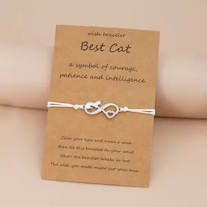 White woven rope bracelet with cat infinity heart charm on a brown gift card