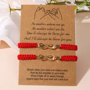 Braccialetti dell'amicizia rossi intrecciati con infinito e cuore su biglietto