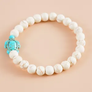 Bohemian armband met witte marmeren kralen en een turquoise schildpad bedeltje